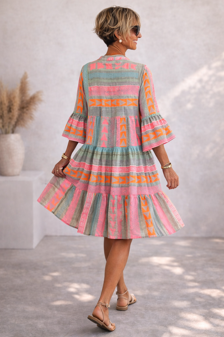 Rosa Damen Midi-Kleid mit elegantem, geometrischem Muster und fließendem Stoff. Ein gemustertes Sommerkleid mit Rüschendetails.