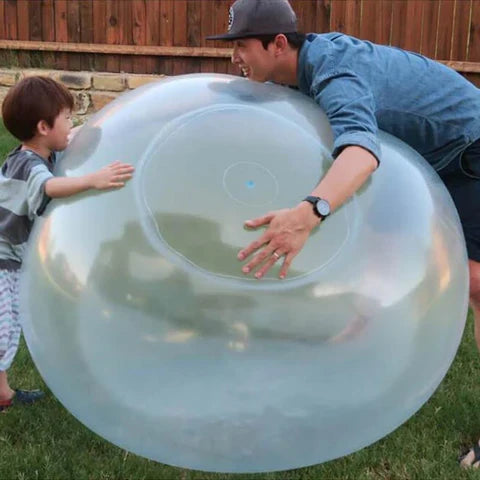 Kind spielt fröhlich mit dem riesigen Bubble-Ball; ideal für Sommer-Wasserspiele & Outdoor-Abenteuer.