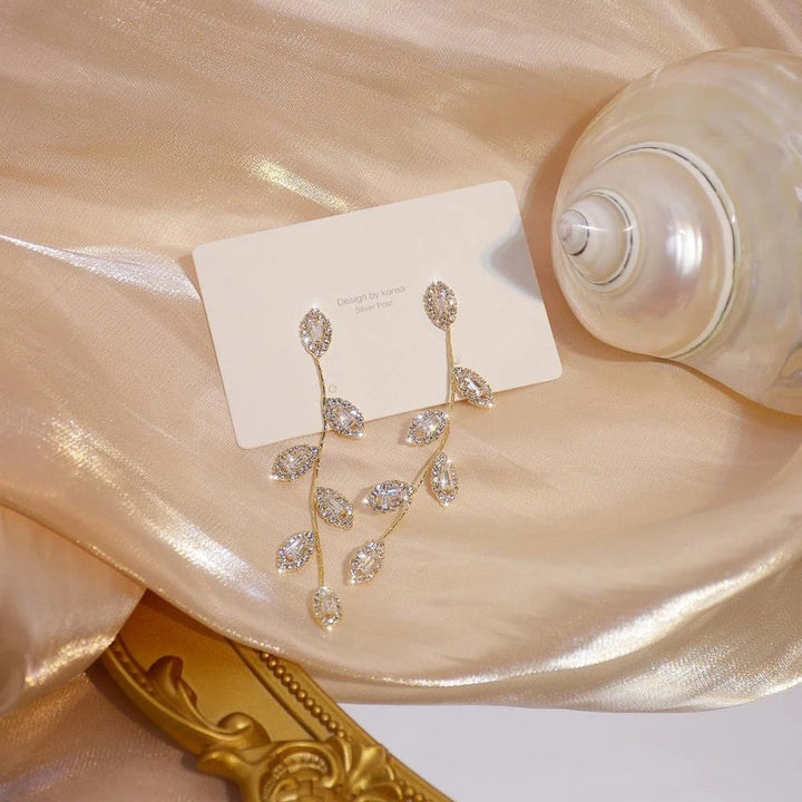 Nahaufnahme goldener Blattohrringe für Damen; zarte Struktur, elegantes Blatt-Design, edler Goldschmuck.