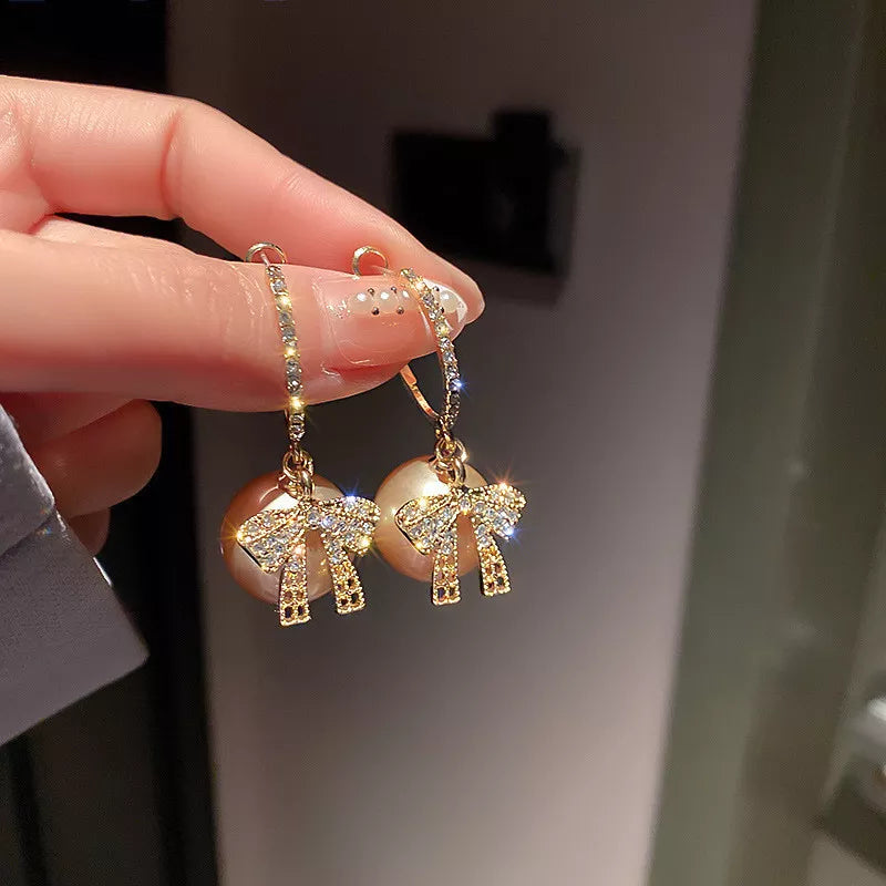Elegante Perlenohrringe für Weihnachten mit glamourösen Schleifendetails, perfekter Festschmuck für Damen.
