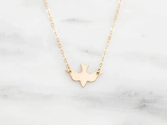 Detailaufnahme der zarten Damenhalskette mit glänzendem Vogel-Anhänger, filigraner Schmuck, tolle Geschenkidee.