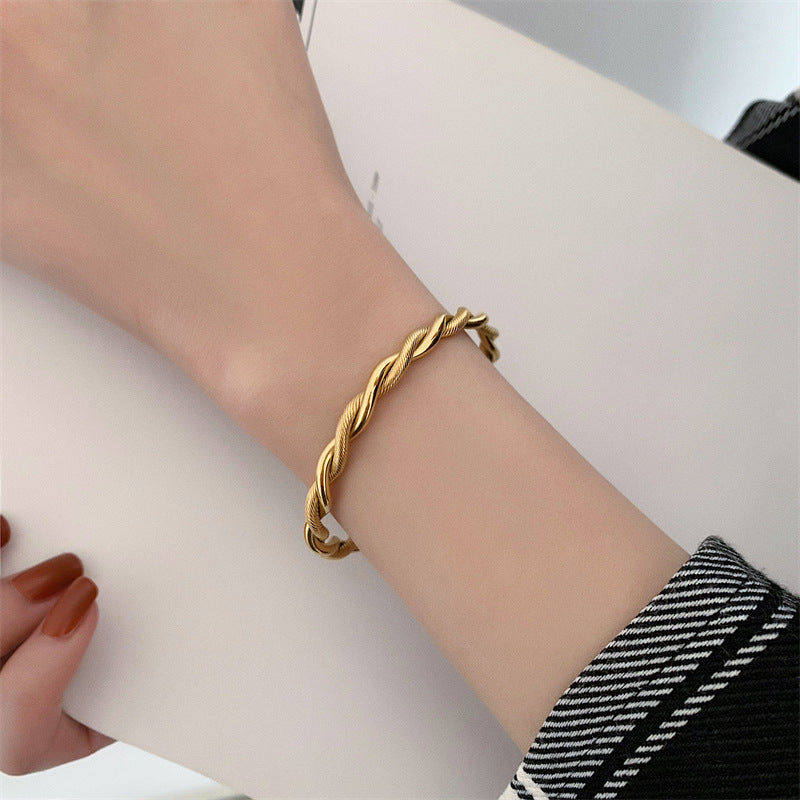 Goldfarbenes Damen Twist Armband, elegantes Manschettenarmband aus Edelstahl, verstellbar für optimalen Sitz.
