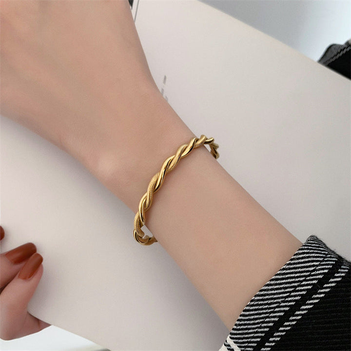 Goldfarbenes Damen Twist Armband, elegantes Manschettenarmband aus Edelstahl, verstellbar für optimalen Sitz.