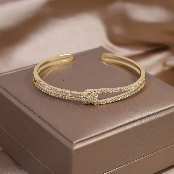 Damen Eleganter Kristallarmreifen mit Goldknoten für zeitlosen Glanz und Stil.