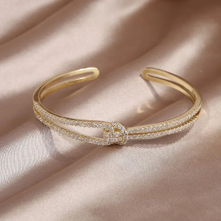 Funkelnder Damen Armreif als luxuriöses Accessoire, mit Kristallen und Goldknoten.