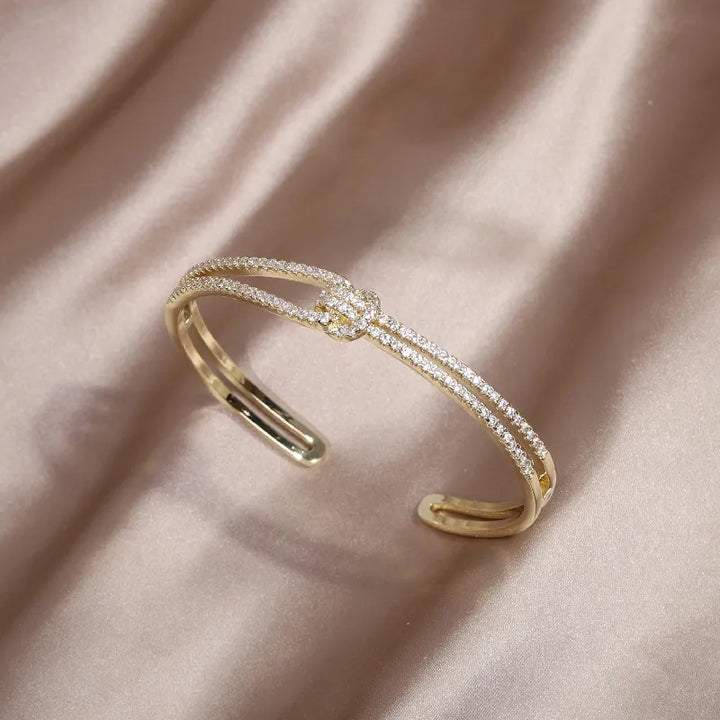 Eleganter Damen Kristallarmreifen mit Goldakzenten und edlem Knoten – Schmuck für Sie.