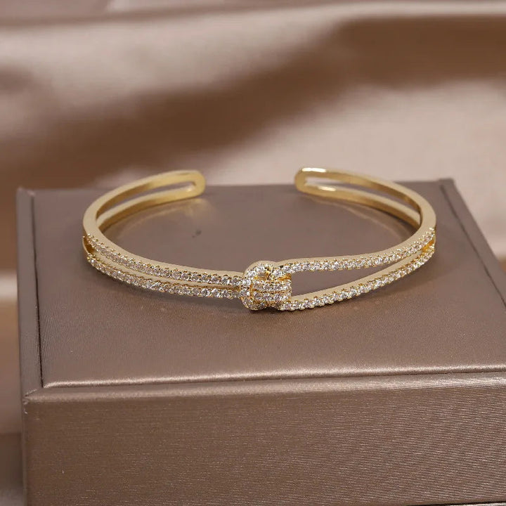 Elegantes Damen Knotenarmband aus goldfarbenem Edelstahl mit Zirkon-Akzenten, perfekt als Schmuck-Geschenk.