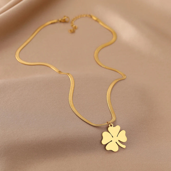 Nahaufnahme der eleganten Kleeblatt-Anhänger an einer Damen Halskette aus glänzendem Edelstahl Schmuck.