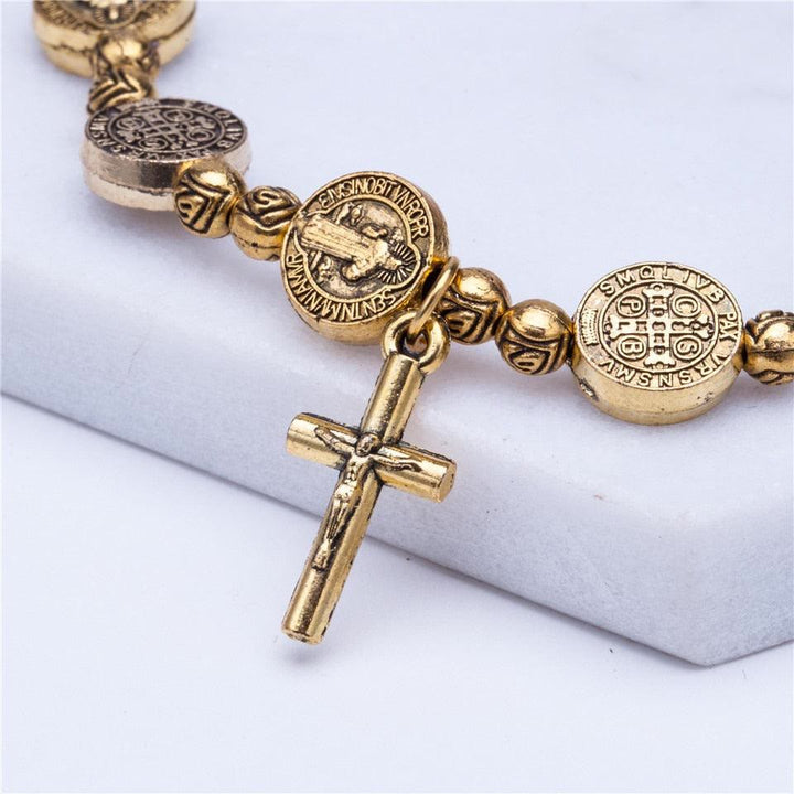 Detailaufnahme: Elegantes Unisex-Kreuzarmband, gold- & silberfarben, aus robustem Metall, als Glaubensschmuck.