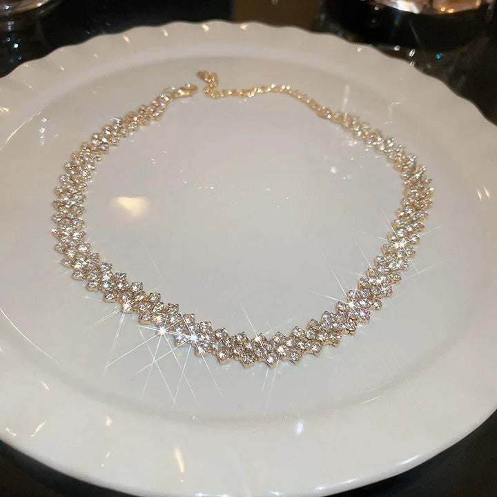 Glamouröse Statement-Halskette für Damen mit goldenem, geometrischem Design und glitzernden Gala-Strasssteinen.