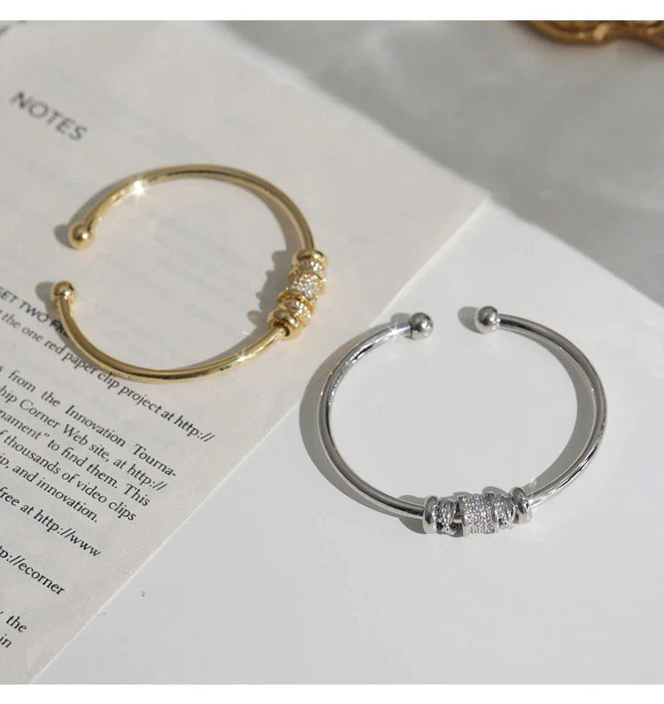 Nahaufnahme eines eleganten zylindrischen Damenarmreifs in Gold, moderner französischer Schmuck für besondere Anlässe.