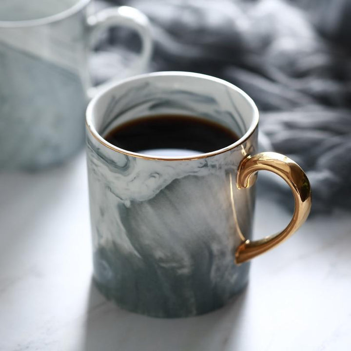 Goldrandige Marmor Kaffeetasse aus Keramik für luxuriösen Morgenkaffee oder Tee.
