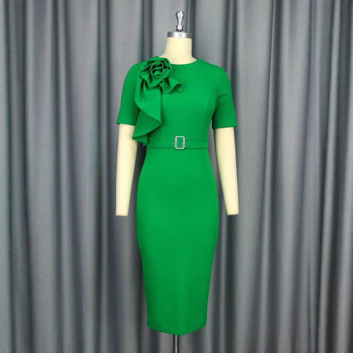 Feminines Abendkleid in Grün, figurbetont geschnitten, mit stilvollem Gürtel und zarter Blütenapplikation.
