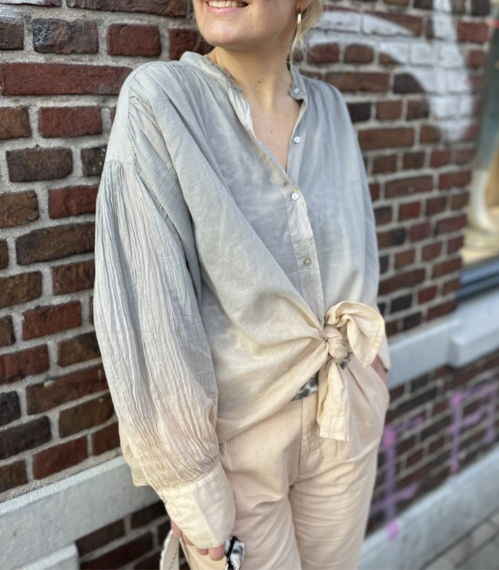 Graubeige Damenbluse mit einzigartiger Textur, elegant und langärmlig. Perfekt für Business-Casual und Alltagsmode.