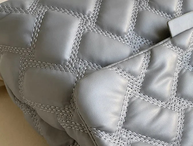 Umhängetasche Damen, gesteppt, mit glänzenden Metall-Akzenten für Eleganz.