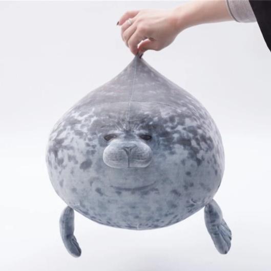 Graues, flauschiges Seehundkissen als weicher Plüschtier-Begleiter, ideal für gemütliche Stunden.