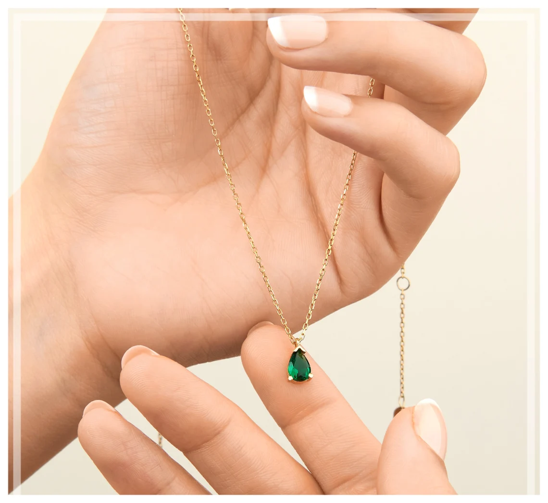 Nahaufnahme der edlen Smaragd-Tropfen-Halskette für Damen, vergoldeter Schmuck mit Strass.