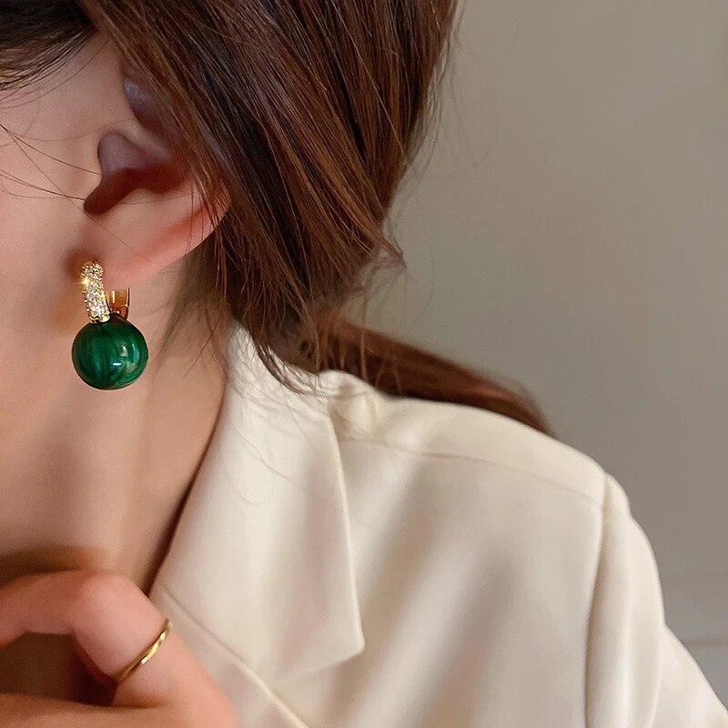 Runde grüne Perlenohrringe für Damen, verziert mit Zirkonen. Zeitlos elegante Partyohrringe.