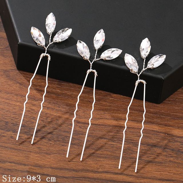 Detailaufnahme von Braut Haarnadeln mit glänzenden Strassblumen und zarten Perlen, perfekt für Hochzeitsfrisuren.