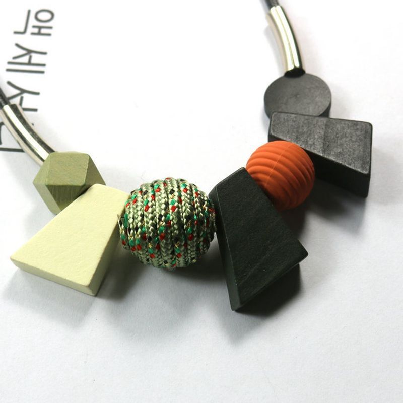 Frau trägt ethnische geometrische Halskette aus Holzperlen, handgemachtes Boho-Accessoire.