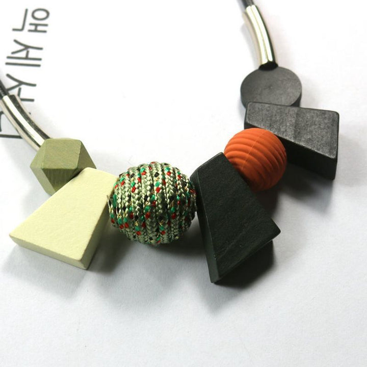 Frau trägt ethnische geometrische Halskette aus Holzperlen, handgemachtes Boho-Accessoire.