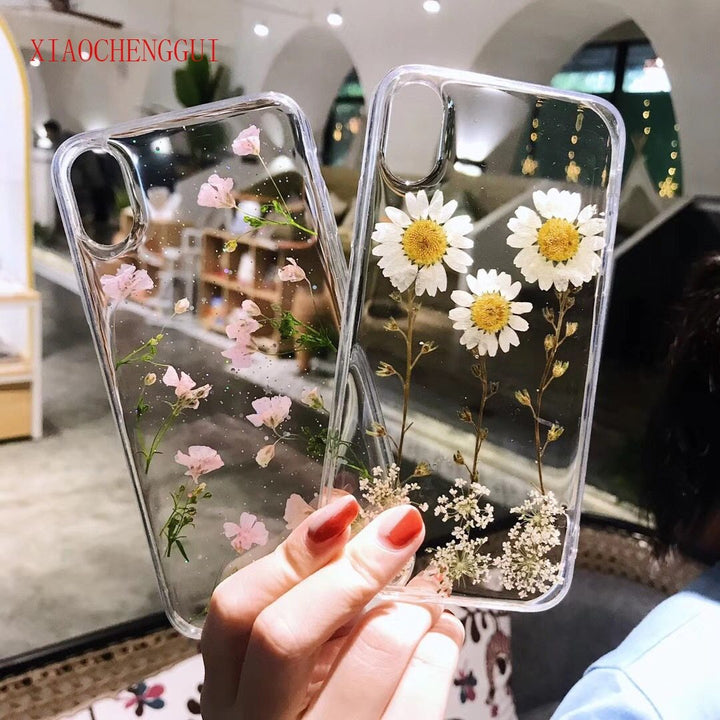 Detailaufnahme der transparenten iPhone Hülle mit eingebetteten, farbenfrohen echten Trockenblumen. Blumen Design.