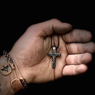 Nahaufnahme des handgefertigten Kreuz-Anhängers an einer Lederkette, ein einzigartiges spirituelles Schmuckstück.