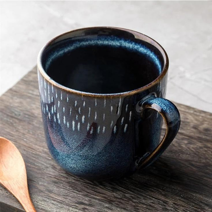 Blauer Keramikbecher mit detailreichem Sternenhimmel-Muster, handgefertigt für gemütliche Momente. Tolles Wohnaccessoire.