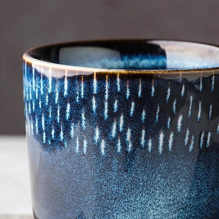 Robuster handgemachter blauer Keramikbecher mit funkelnden Sternen, als Tasse für warme Getränke oder Deko.