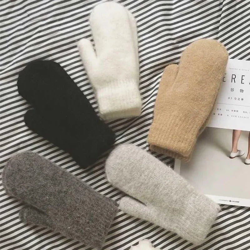 Hände in warmen, kuscheligen Unisex Winter Plüschhandschuhen, perfekt für frostige Tage. Trendige Fäustlinge.