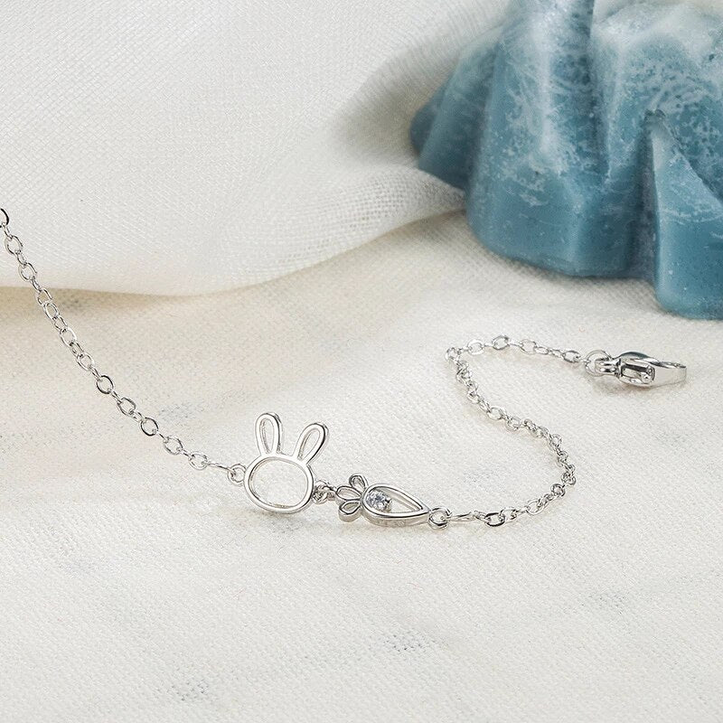 Nahaufnahme: Glänzender Kaninchen-Anhänger am silbernen Damenarmband, fein gearbeiteter Symbolschmuck.