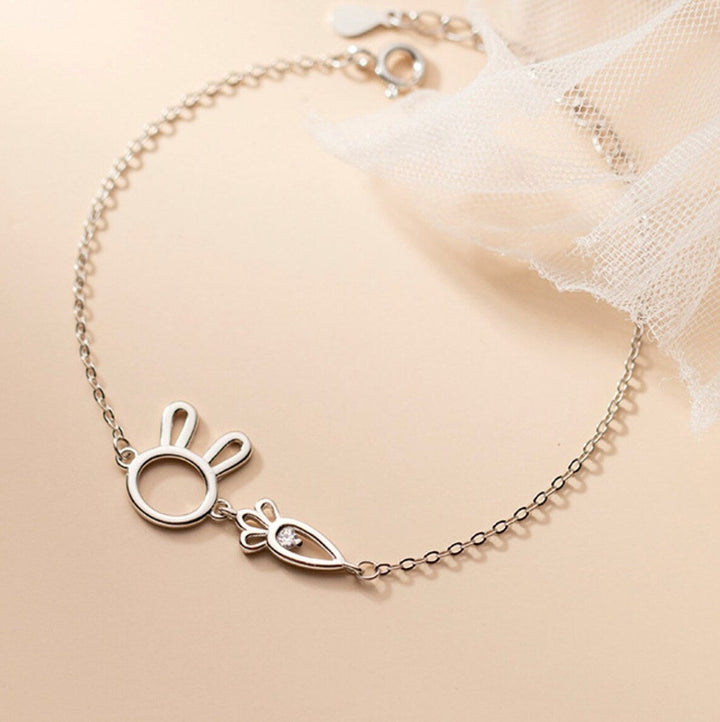 Damenarmband aus Silber mit Kaninchen-Glücksbringer, elegant am Handgelenk einer Frau getragen.
