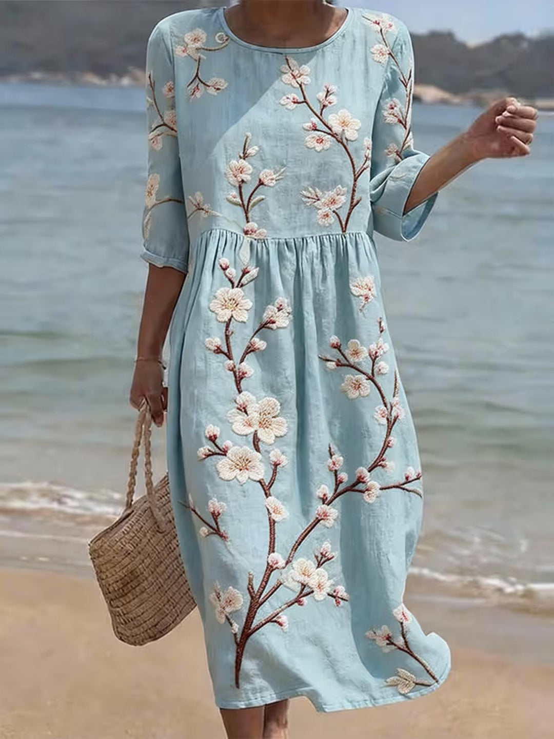 Hellblaues Damen-Midikleid mit eleganten Ellenbogenärmeln und lässigem Blumendruck, ideal für den Sommer.