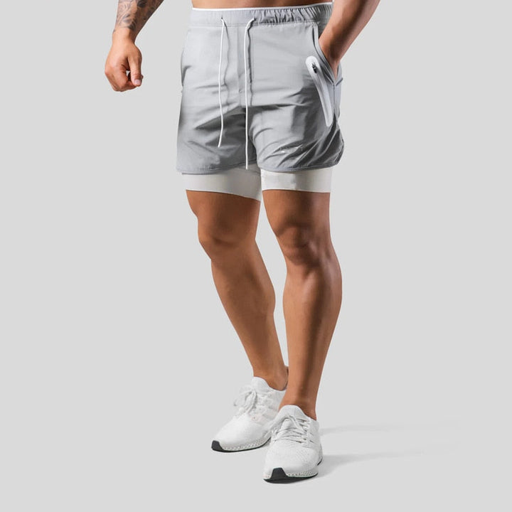 Aktiver Mann in Herren 2-in-1-Sportshorts Mauro beim dynamischen Training im Fitnessstudio.