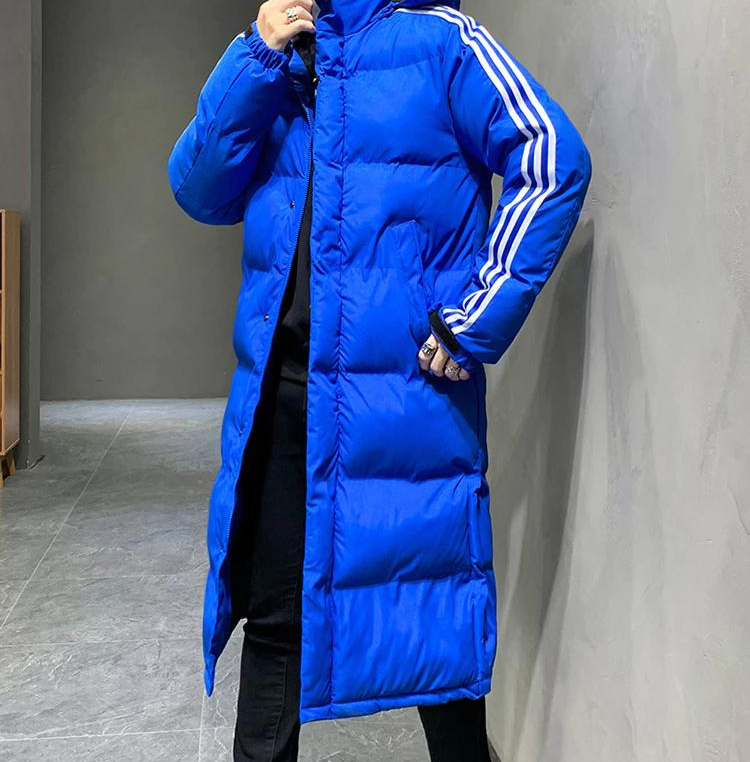 Mann spaziert in wetterfester Herren Dekan Winterjacke, langes Modell mit Kapuze, warm und komfortabel.