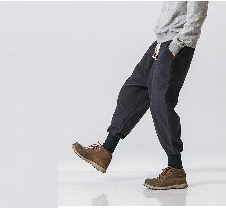 Mann trägt lässige Streetwear Haremshose, kombiniert mit Sneakers & Hoodie.
