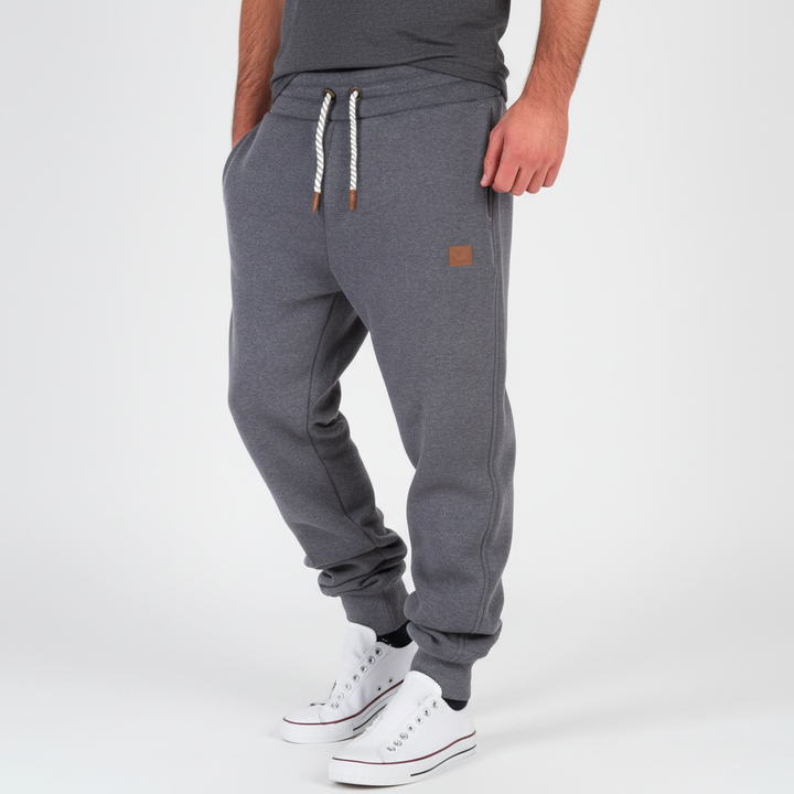 Nahaufnahme der schmal geschnittenen Herren Jogginghose, betont den modernen Schnitt und die hochwertige Textur.