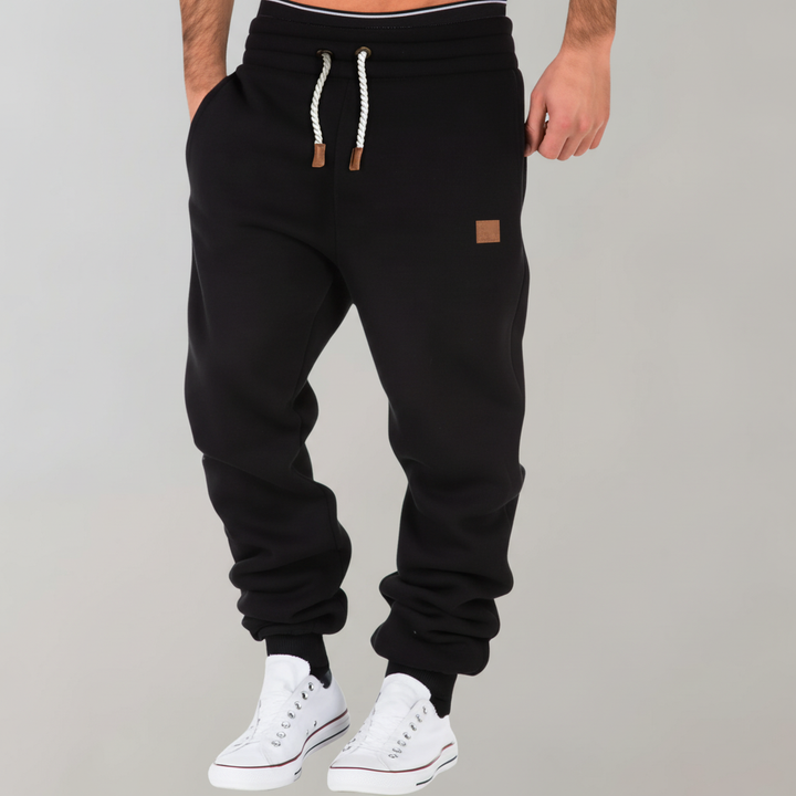 Mann trägt schmale Jogginghose Lance, präsentiert den eleganten, bequemen Fit für Freizeit und Alltag.