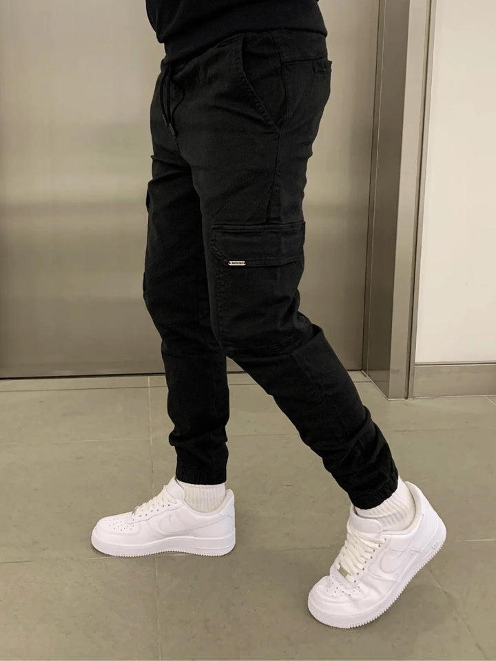 Detailansicht der praktischen Cargotaschen an den schmalen Herren-Jogginghosen, ideal für Handy oder Schlüssel.