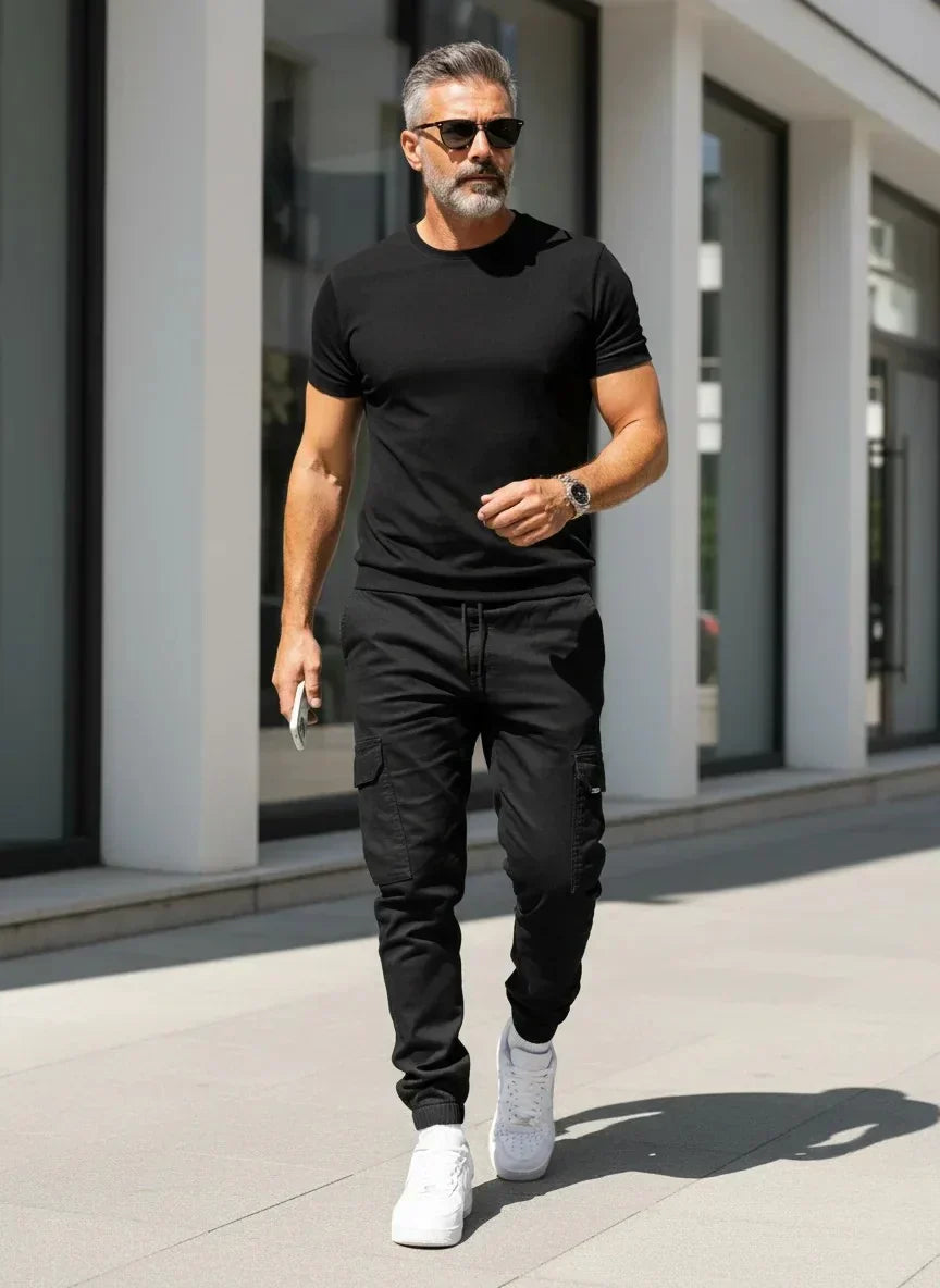 Mann trägt stylische schmale Cargo-Jogger, kombiniert mit T-Shirt, zeigt bequemen und modischen Freizeitlook.