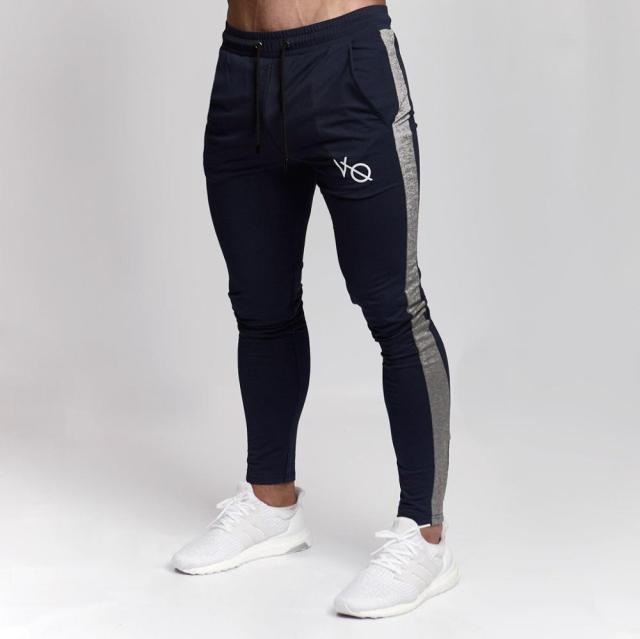 Mann in Slim Fit Trainingshose, entspannt auf der Couch, demonstriert Alltagstauglichkeit.