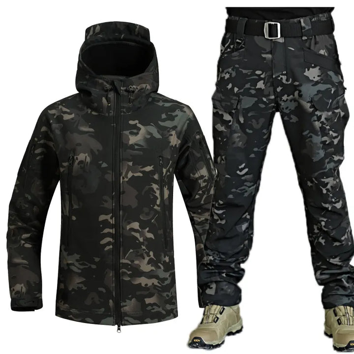 Mann in wetterfestem Herren Outdoor-Set beim Wandern. Robuste Outdoorbekleidung für winterliche Abenteuer.
