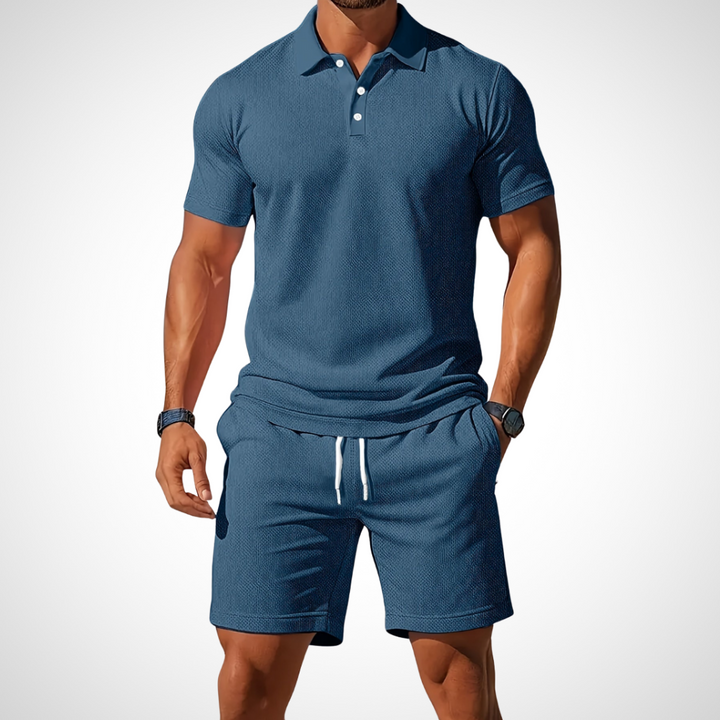 Mann präsentiert lässiges Herren Poloshirt und Shorts Set, perfekt für warme Sommertage.