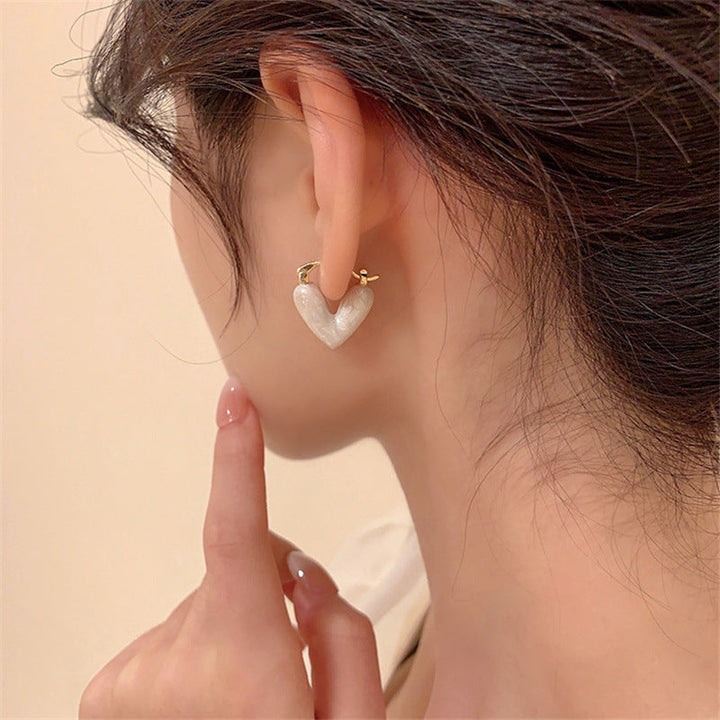 Zarte Ohrringe für Damen, goldfarben mit Herzmotiv und kleinen glitzernden Details, Accessoire.