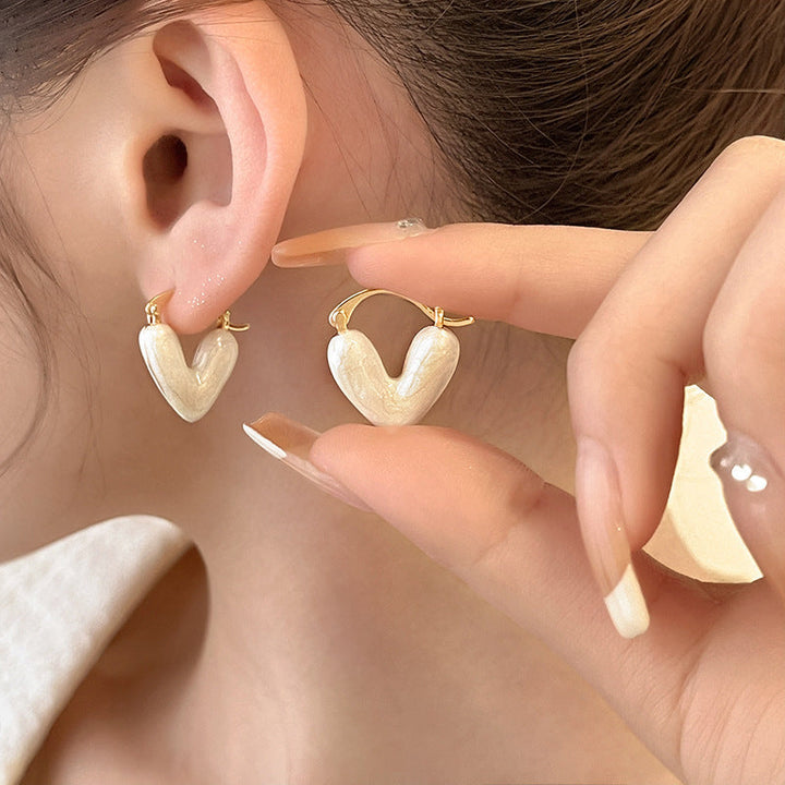 Zeitloser Liebesmotiv-Ohrstecker für Damen, goldfarben, mit schimmernden Kristallen verziert.