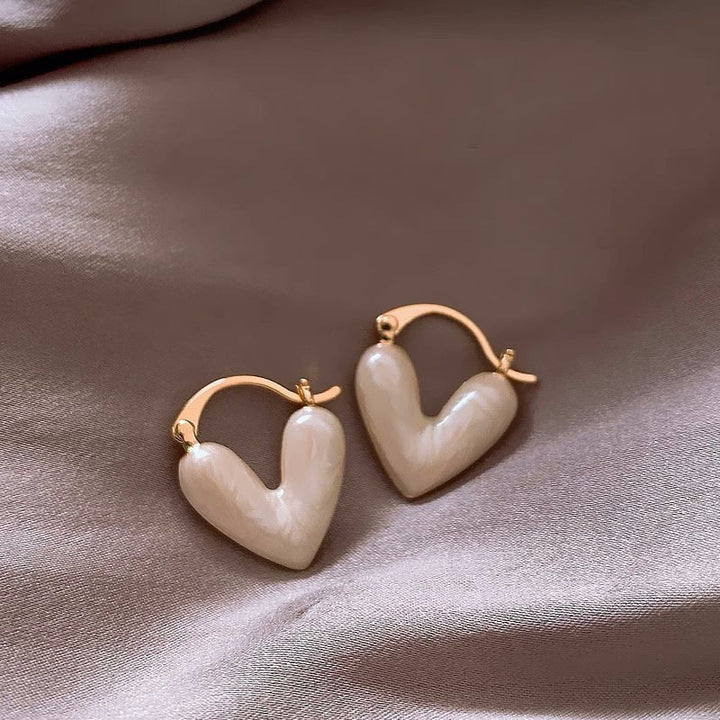 Zarte goldene Damenohrringe mit funkelndem Herz aus Kristall, eleganter Modeschmuck.