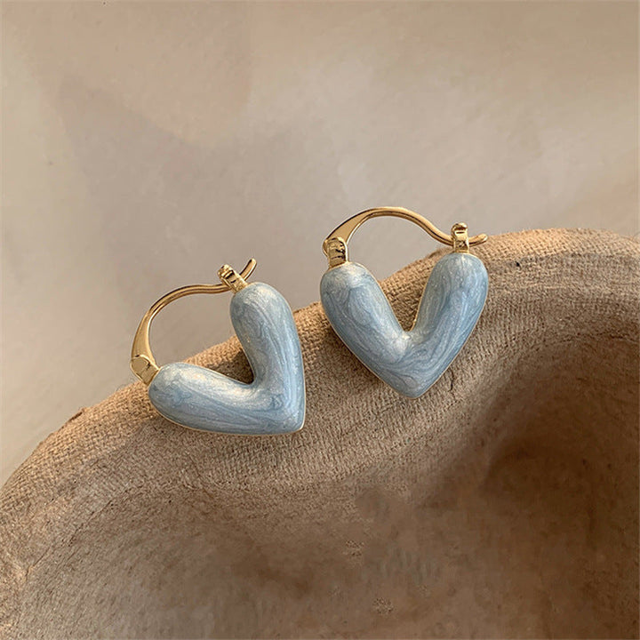 Romantische Geschenkidee: elegante goldene Herz-Ohrstecker für Damen mit funkelnden Steinen.
