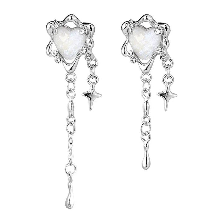 Nahaufnahme der Damen Herz-Ohrringe mit zarten Sternen und verspielten Quasten. Eleganter Edelstahlschmuck.