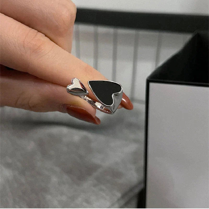 Verstellbarer Herzring in Schwarz am Finger einer Dame, stilvolles Accessoire.
