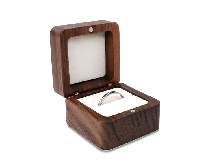 Elegantes Schmuckkästchen aus Holz, offen, zeigt Fächer für Ringe und Ohrstecker auf weichem Samt.